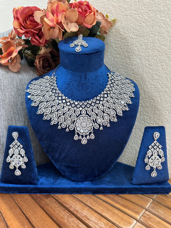Close view of floral American diamond bridal necklace set on blue velvet display