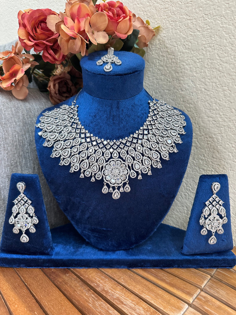 Close view of floral American diamond bridal necklace set on blue velvet display