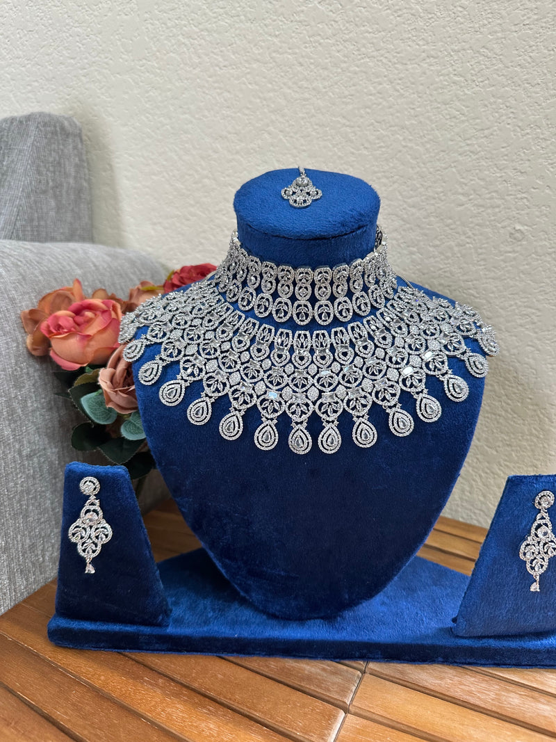 Close view of silver American diamond bridal necklace set on blue velvet bust