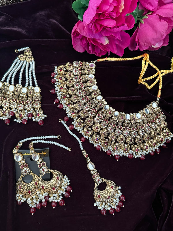 Antique gold bridal necklace set with red stones, jhumar, tikka and earrings