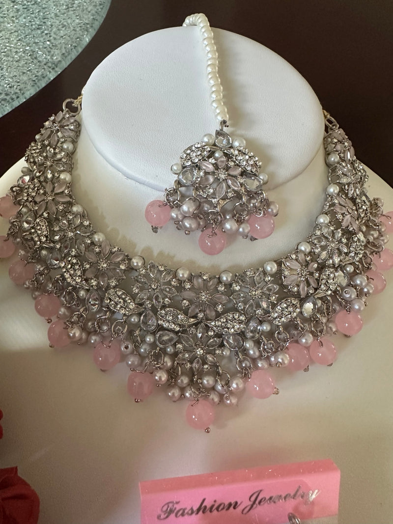 Close-up of blush pink American diamond floral choker necklace with pearl accents and matching tikka