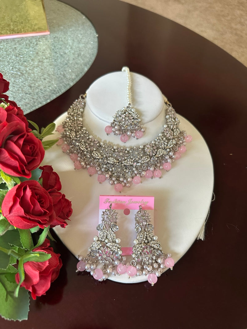 Full display of blush pink American diamond choker necklace set with matching earrings and tikka