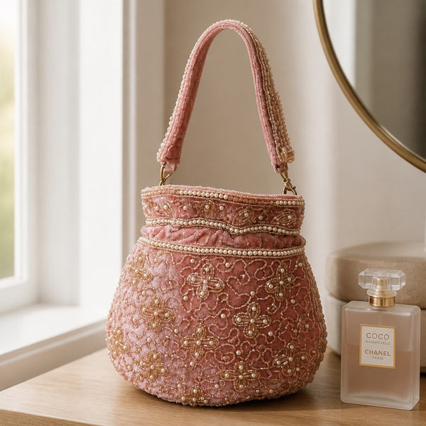Blush pink handmade Indian potli bag with floral pearl beadwork and embellished carrying handle