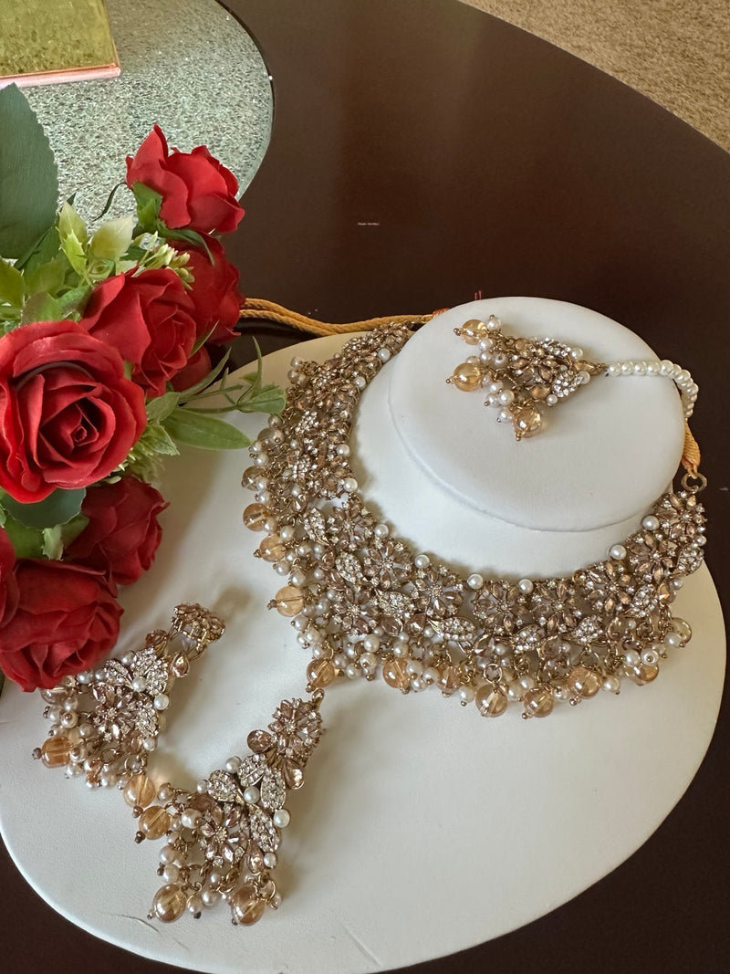 Side view of champagne gold American diamond choker necklace set with matching earrings and tikka