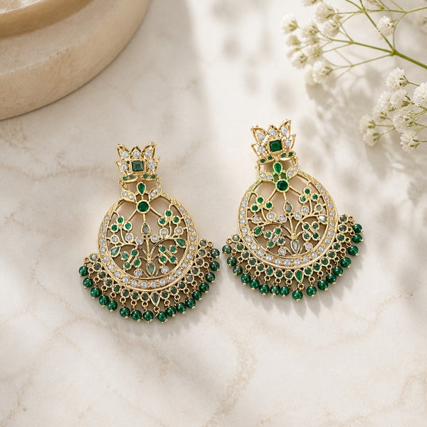 Ornate emerald green kundan-style chandbali earrings with floral filigree detail