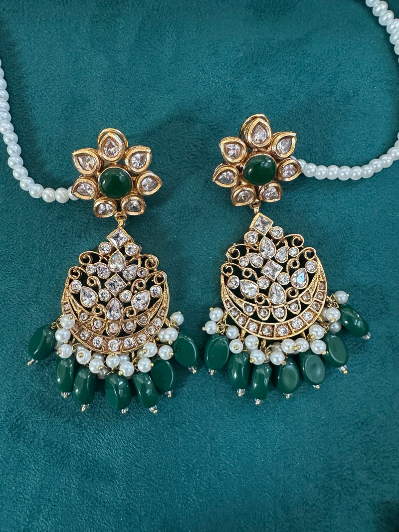 Emerald green kundan chandbali earrings shown on hand