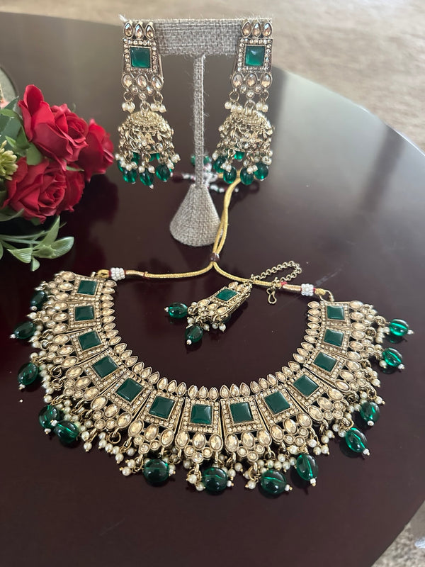 Emerald green kundan necklace set with matching jhumka earrings and tikka
