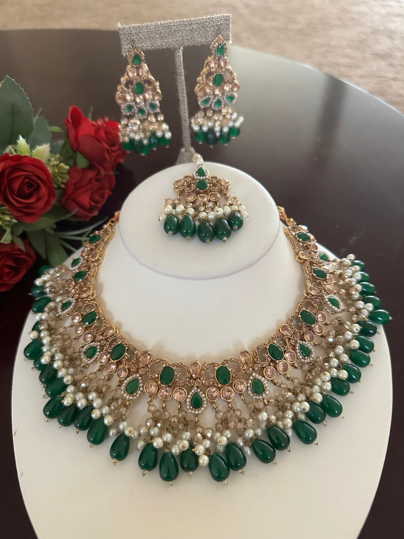 Full view of emerald green kundan bridal necklace with pearl fringe, earrings and tikka