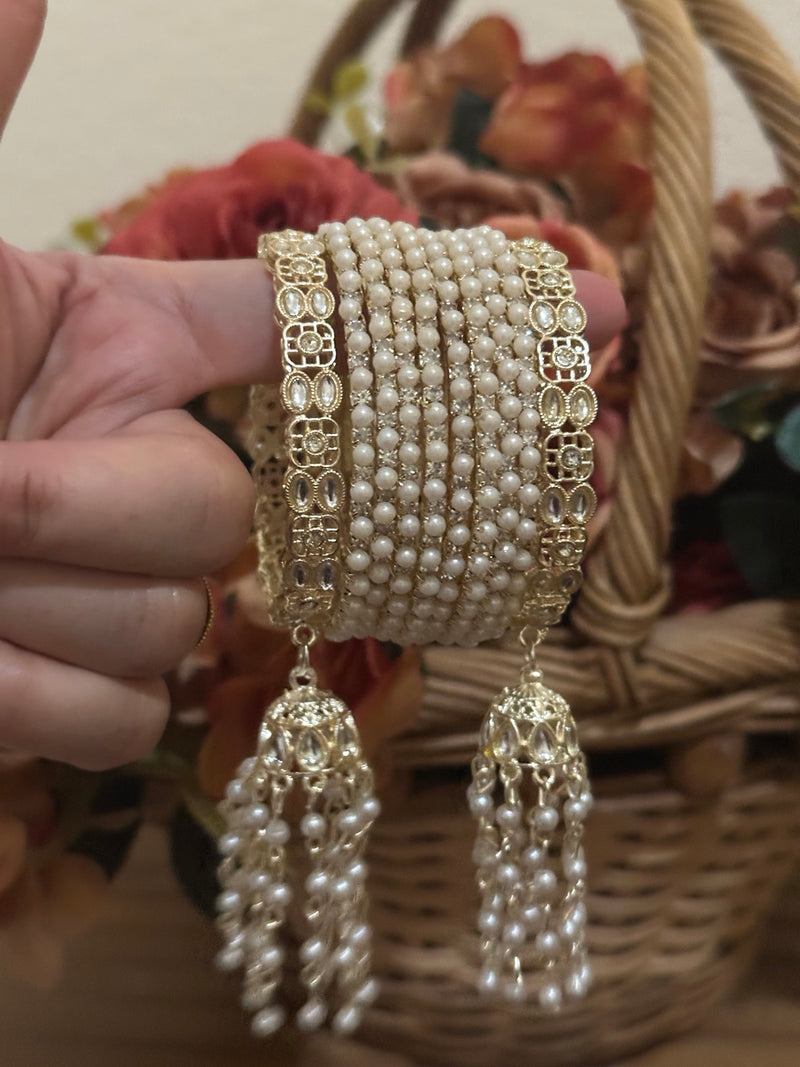 Gold 10-piece pearl bangle set with floral side bangles and hanging jhumka tassels, available in sizes 2.4, 2.6 and 2.8
