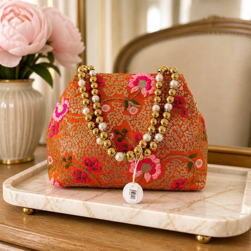 Handcrafted orange floral fabric clutch with pearl and gold bead handle