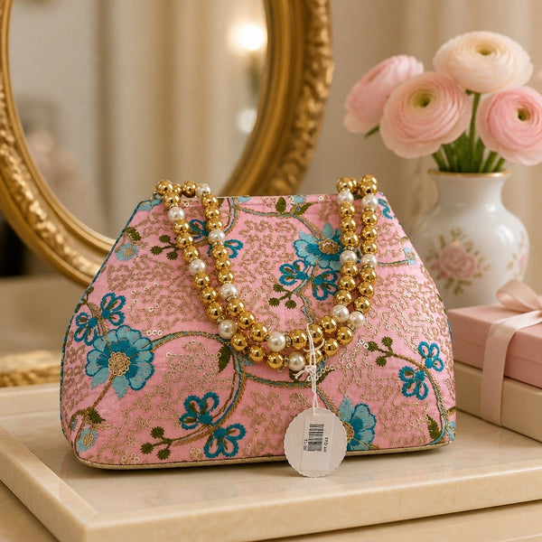 Handcrafted pink floral fabric clutch with pearl and gold bead handle