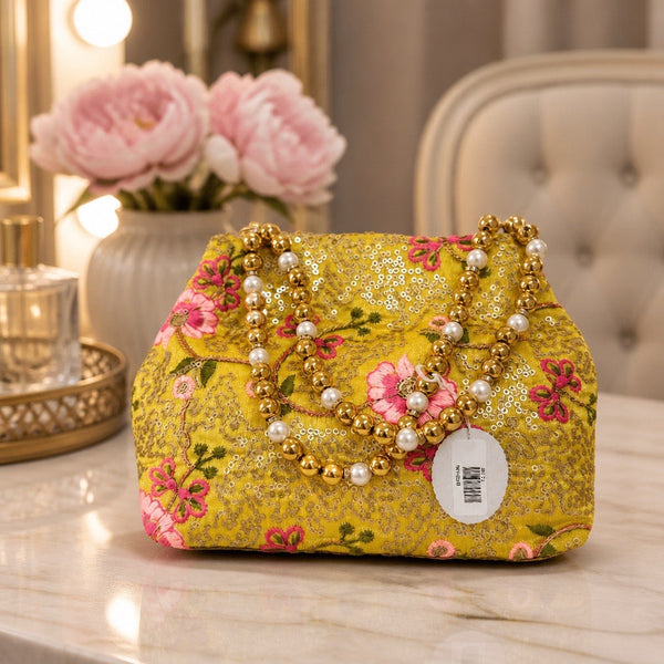 Handcrafted yellow floral fabric clutch with pearl and gold bead handle