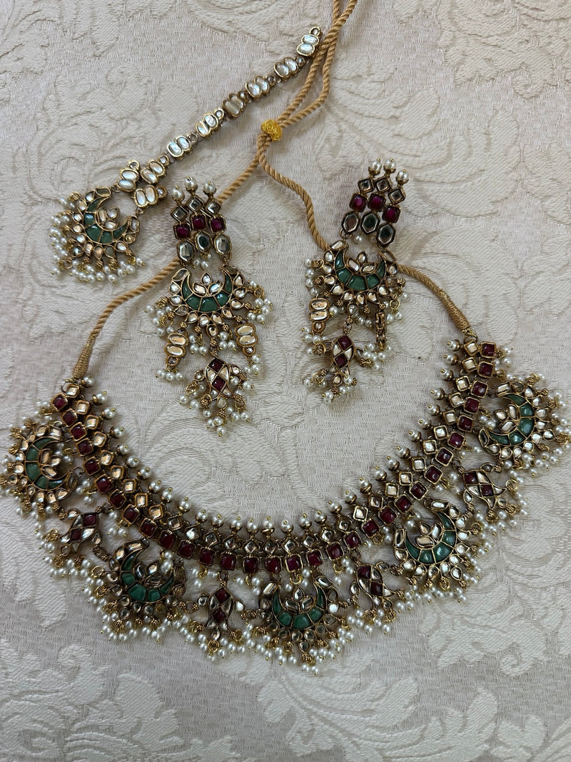 Multicolor kundan bridal set flat lay with necklace earrings and tikka