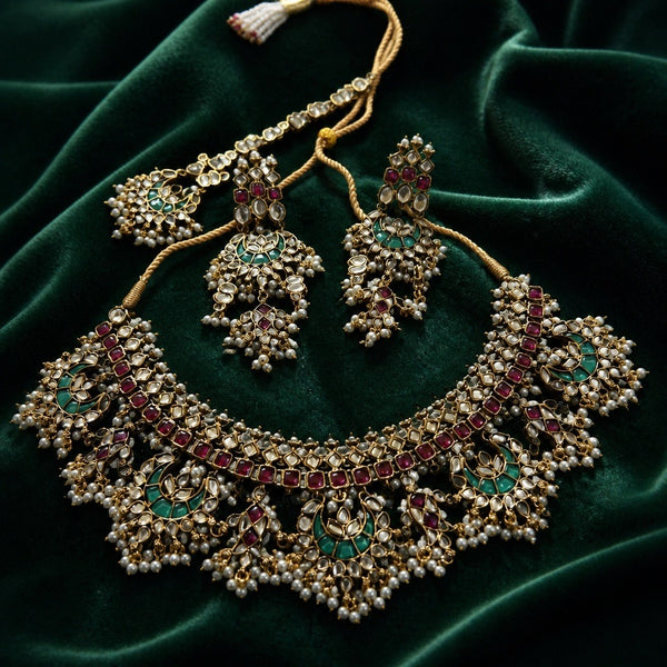 Multicolor kundan bridal necklace set with earrings and tikka on green velvet
