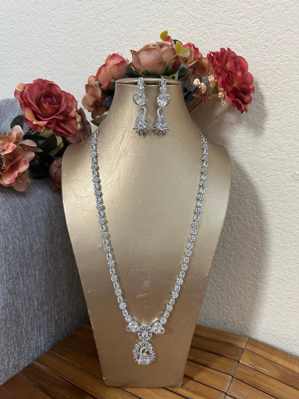 Long American diamond necklace set with matching earrings on gold bust display