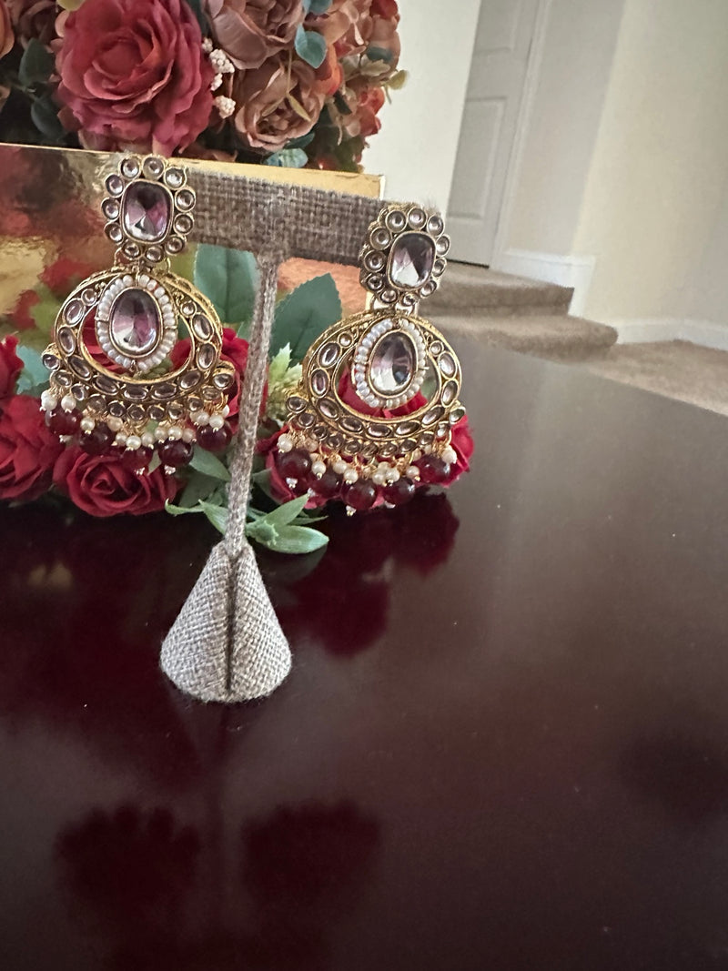 Side view of antique gold maroon kundan earrings with pearl and bead drops