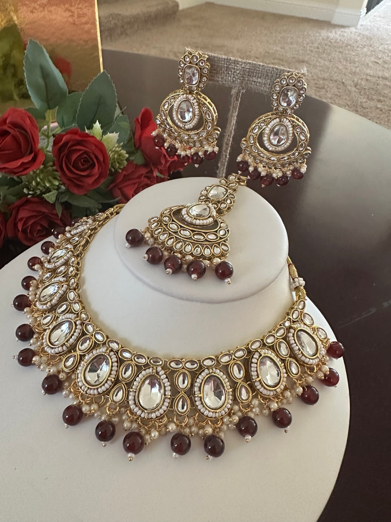 Maroon kundan necklace set with matching statement earrings and tikka