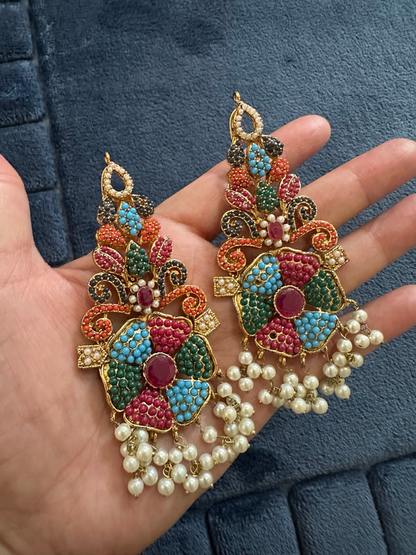 Multicolor floral earrings with blue, pink, green and orange beadwork and pearl-look fringe held in hand