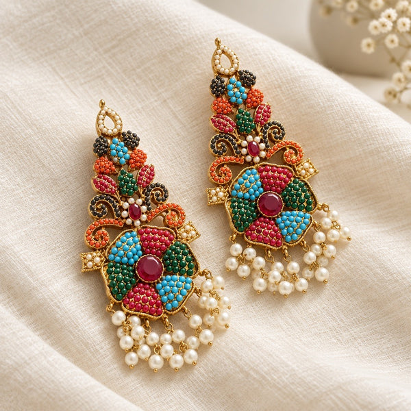 Pair of multicolor floral statement earrings with gold-tone scrollwork and pearl-look fringe on ivory fabric