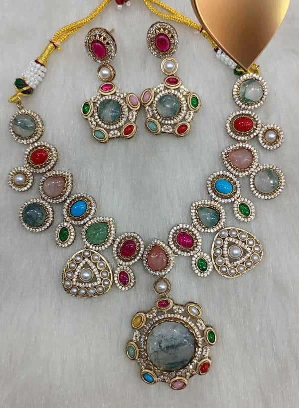Multicolor gemstone statement necklace with matching earrings and large circular pendant displayed on a white background