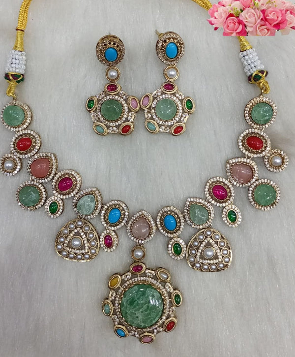 Multicolor green cabochon gemstone statement necklace set with matching earrings and large round pendant displayed on a white background