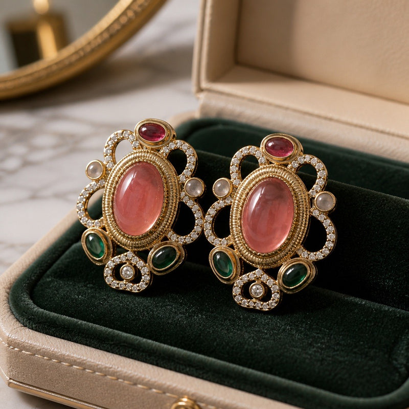 Peach oval stud earrings with emerald green accents and crystal details