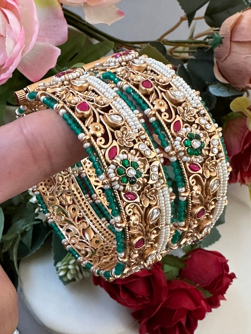 Side view of ornate Rajwari bangles with green beadwork, pink stones, kundan-style details and pearl edging