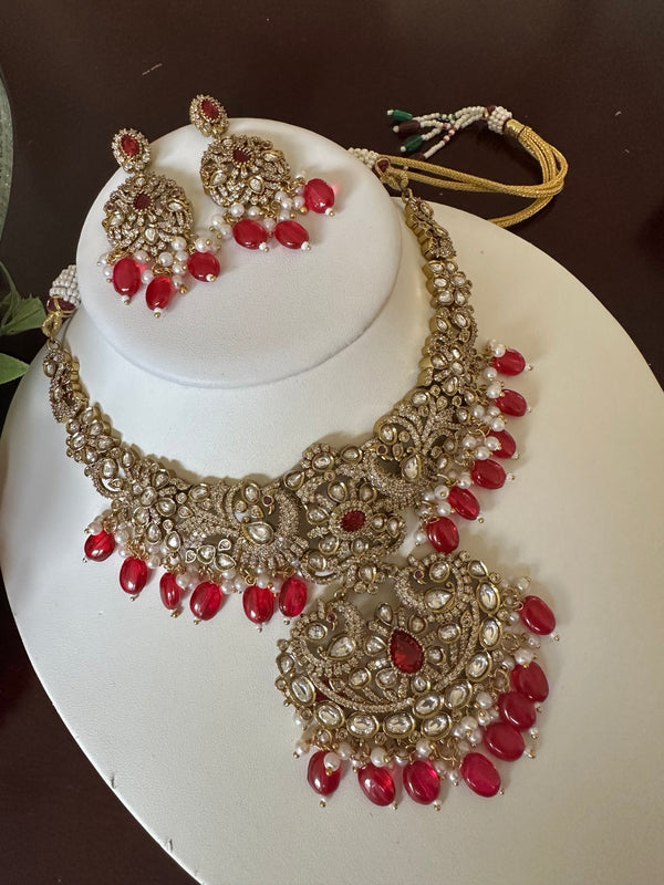 Full view of ruby red Kundan statement necklace set with matching earrings and pearl accents