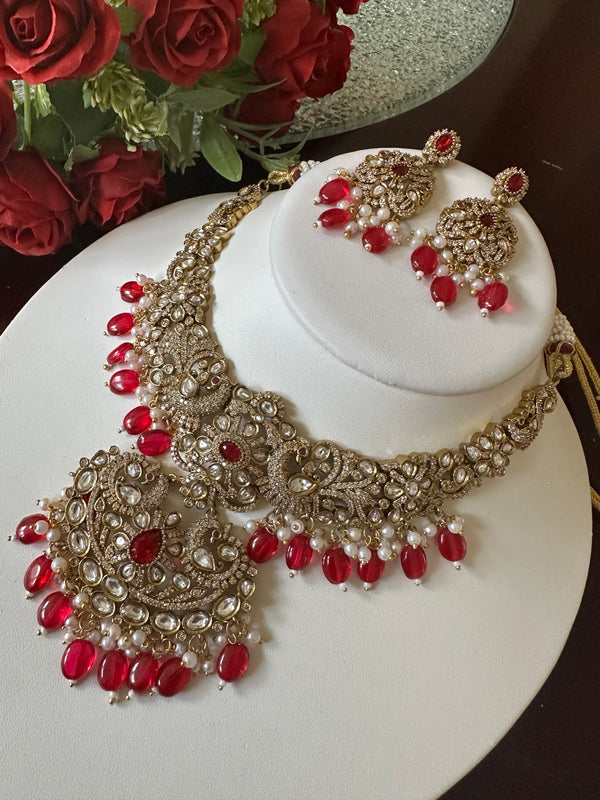 Ruby red Kundan necklace set with large statement pendant and matching earrings shown from the side