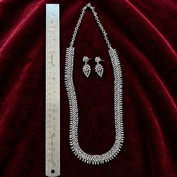 Silver American diamond 24 inch necklace set with matching earrings shown beside a ruler