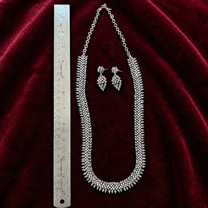 Silver American diamond 24 inch necklace set with matching earrings shown beside a ruler