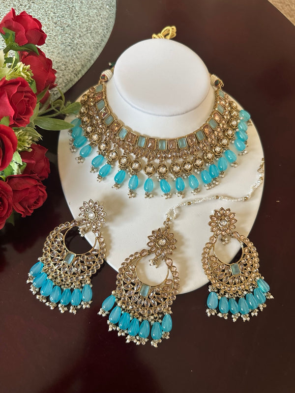 Sky blue Kundan choker necklace set with matching earrings and tikka displayed on a white jewelry bust