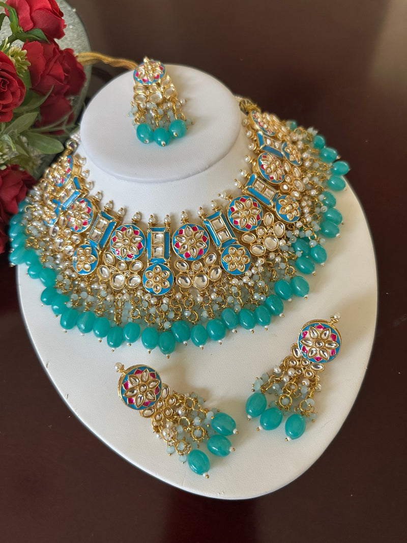Angled view of turquoise blue Kundan choker necklace set with matching earrings and tikka